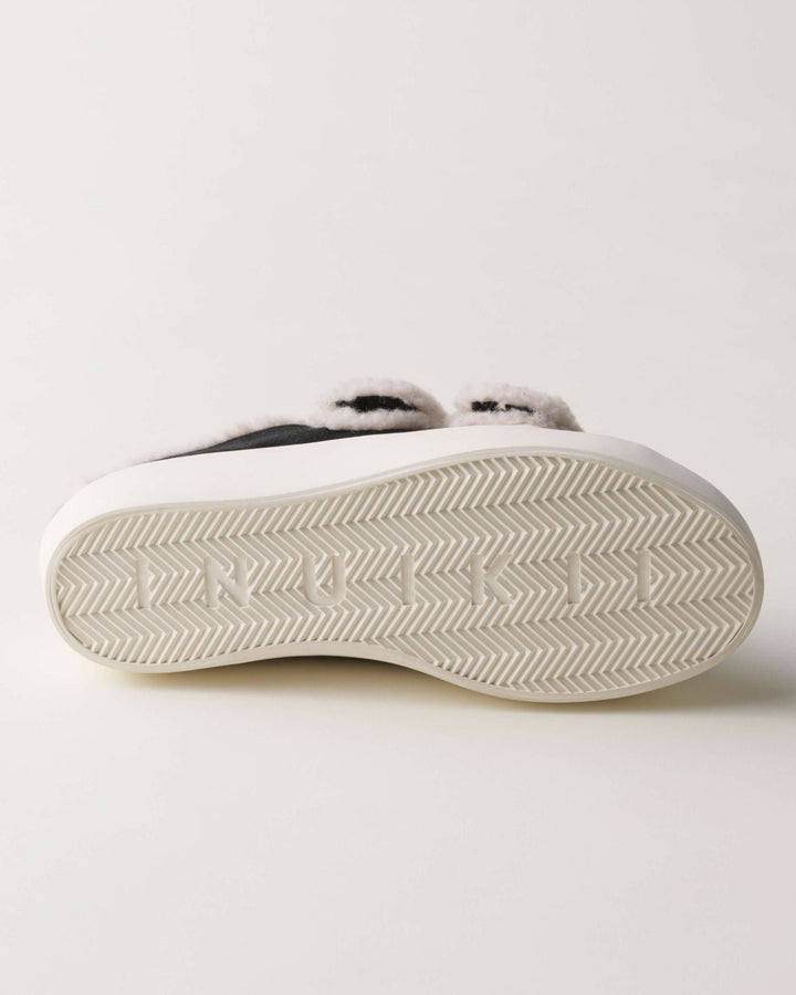 Sål af Inuikii sneaker med sildebensmønster og "INUIKII" indgraveret i hvid gummi.