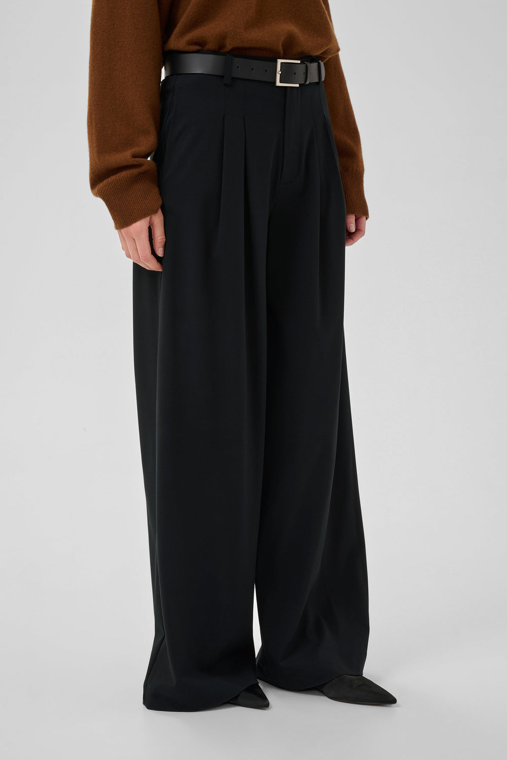 Hace-bukserne fra My Essential Wardrobe er elegante, sorte bukser med høj talje, flatterende læg og vide ben på kvinde