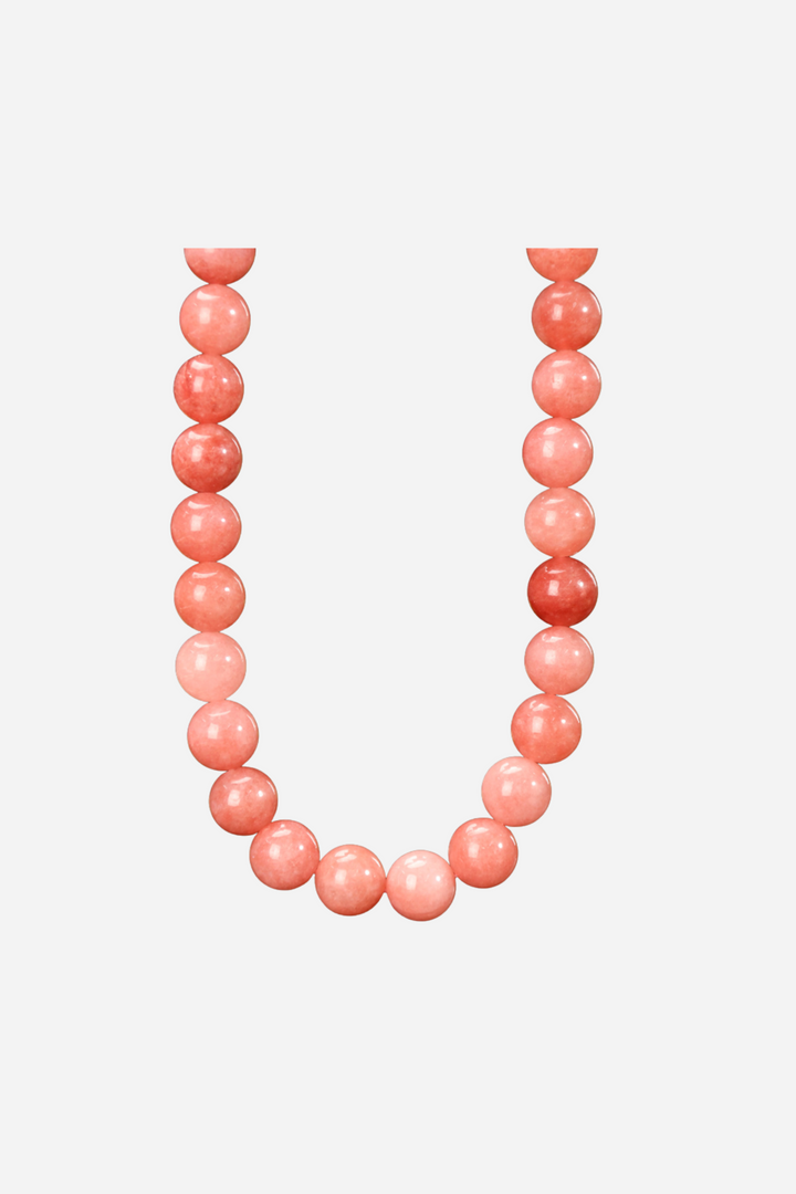 Halskæde med runde, glatte perler i forskellige pink nuancer, formet i en cirkel.