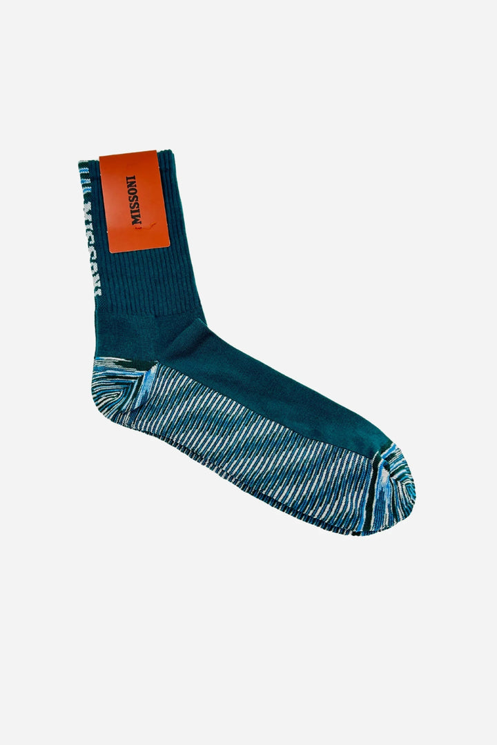 Strømpe i petroleumsblå med ribbet top og stribet fod. Mærkat med "Missoni" på siden.