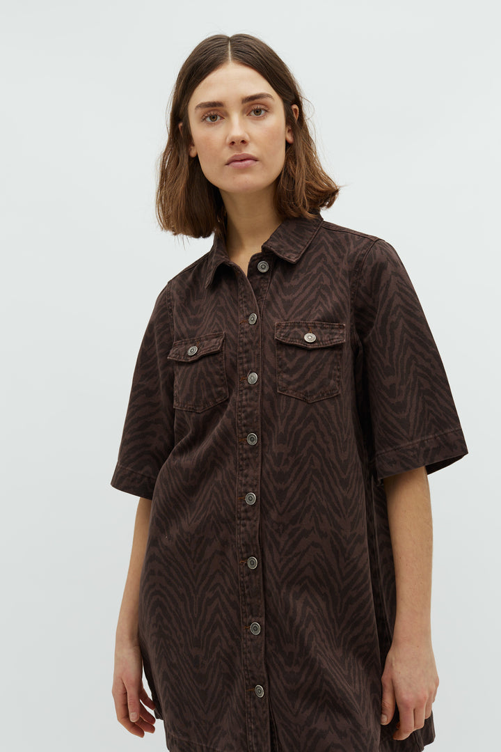 Brun zebra denimkjole med knapper, korte ærmer og brystlommer. Afslappet pasform.