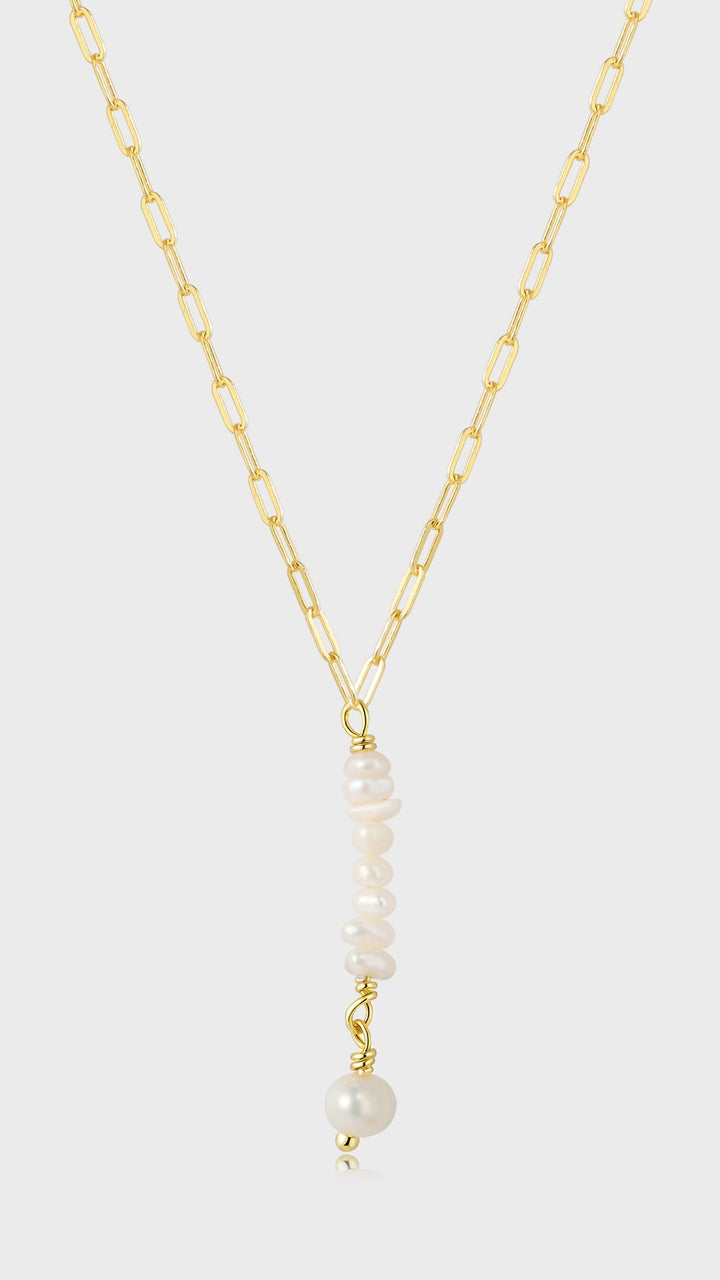 Gylden kæde med aflange led, vedhæng af små hvide perler og en større hvid perle, elegant design.