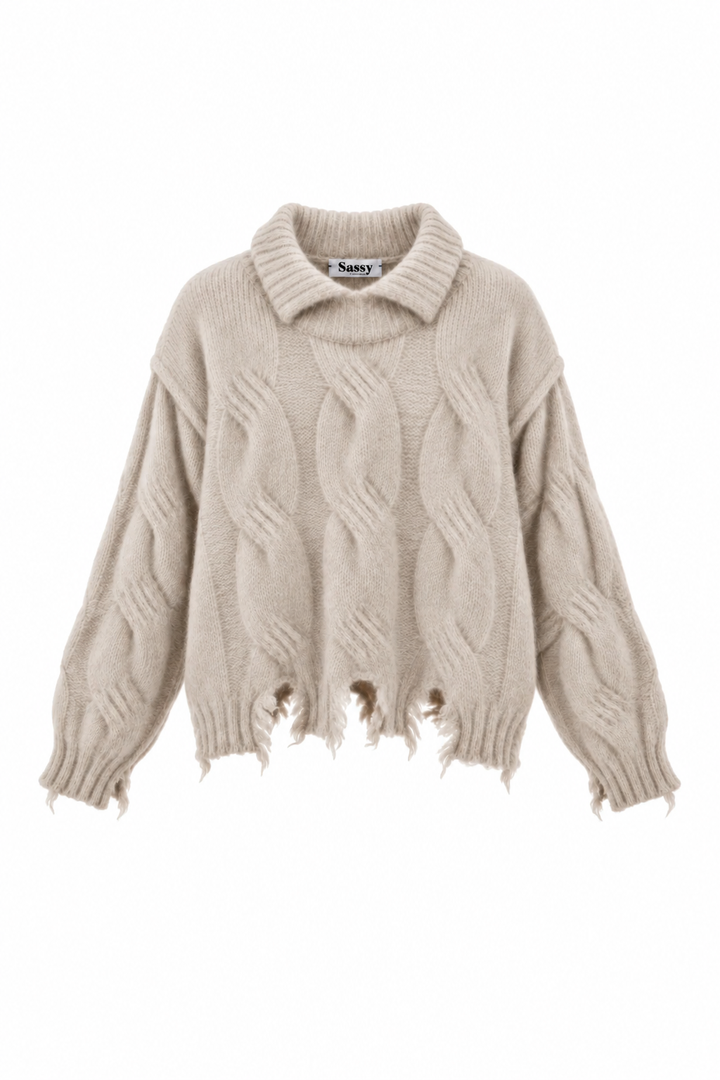 Karla strik fra Sassy Copenhagen er en chunky striktrøje med et markant kabelmønster og et moderne, afslappet udtryk i beige melange