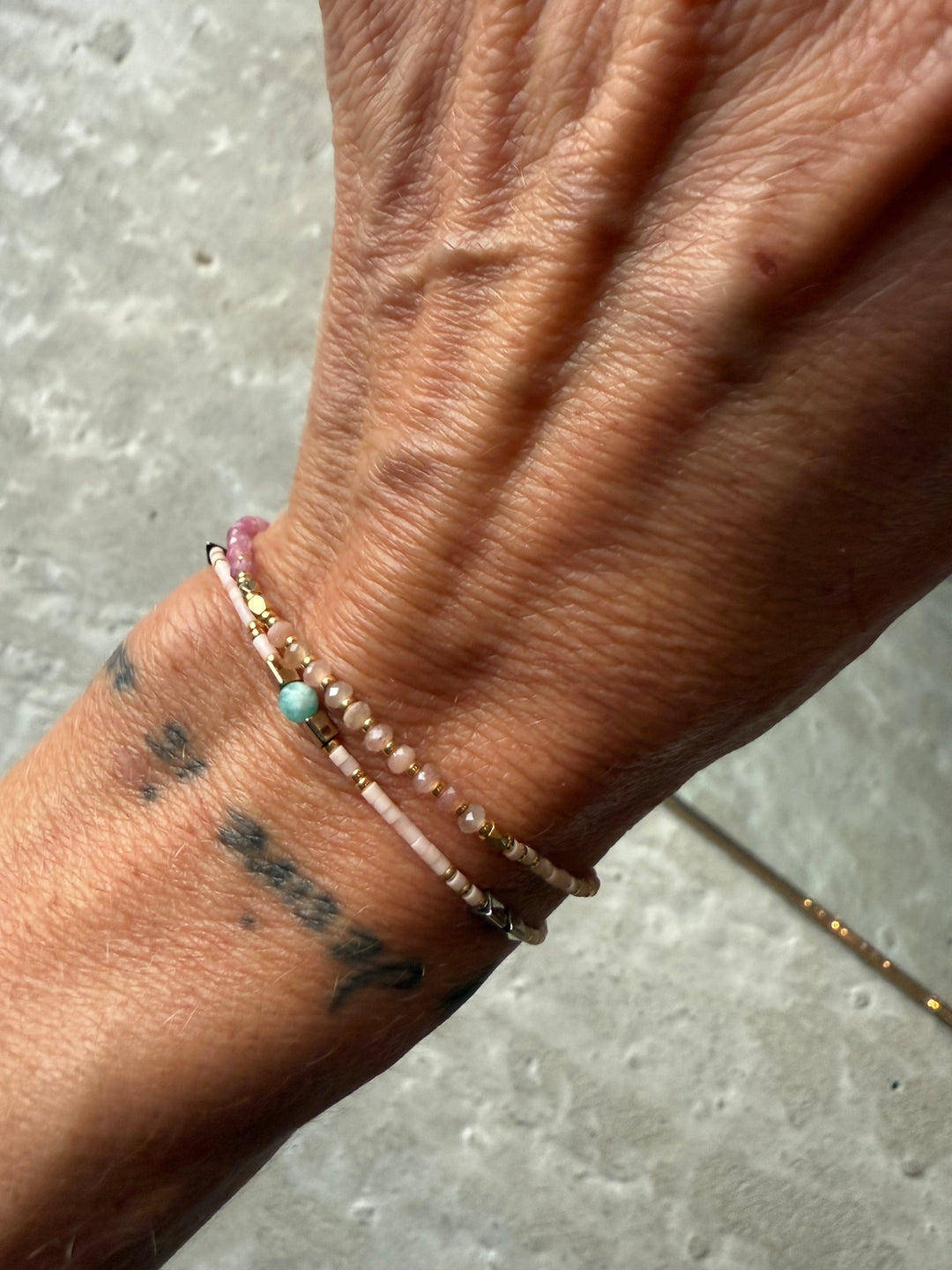 Perlearmbånd i pink blush og guld fra Andcopenhagen Jewelry, model Holly, vist på håndled.