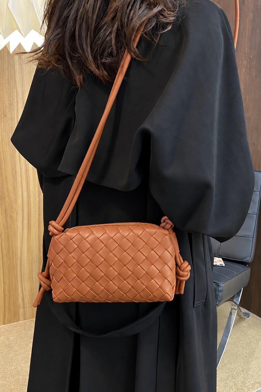 Esmina fra Andcopenhagen er en elegant, lille crossbody-taske i cognacfarvet vegansk læder med et smukt flettet design