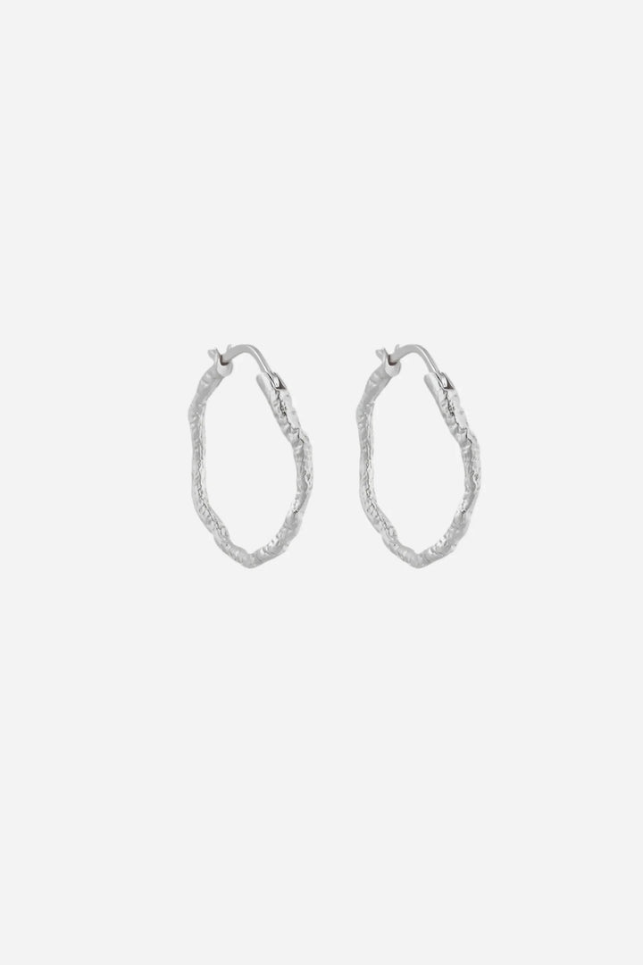 Små hoops øreringe i 925 sterlingsølv med organisk, tekstureret overflade og cirkulær form.