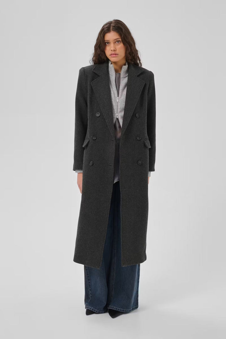 Frannie-frakken fra My Essential Wardrobe er en klassisk, lang frakke i den elegante farve Dark Grey Melange på mørkhåret kvinde
