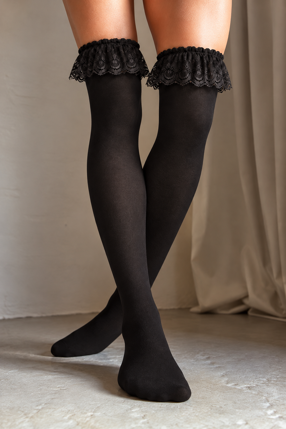 Nikki sorte overknee strømper fra Andcopenhagen med dekorativ blondekant og elastik i toppen. Bløde, elegante strømper i polyamid og elastan.