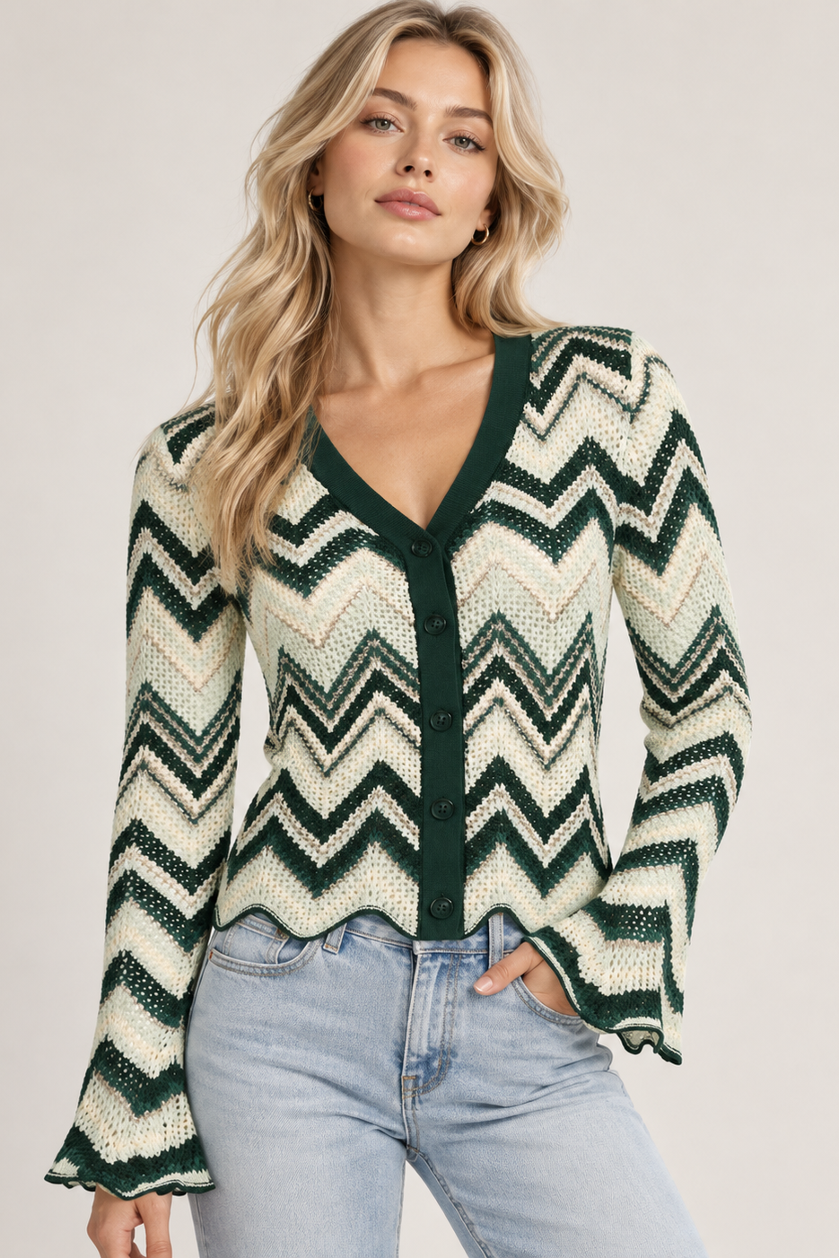 Majken Cardigan fra Sassy Copenhagen er en feminin strikcardigan med et dekorativt zigzagmønster i grønne, cremefarvede og beige nuancer på lyshåret kvinde