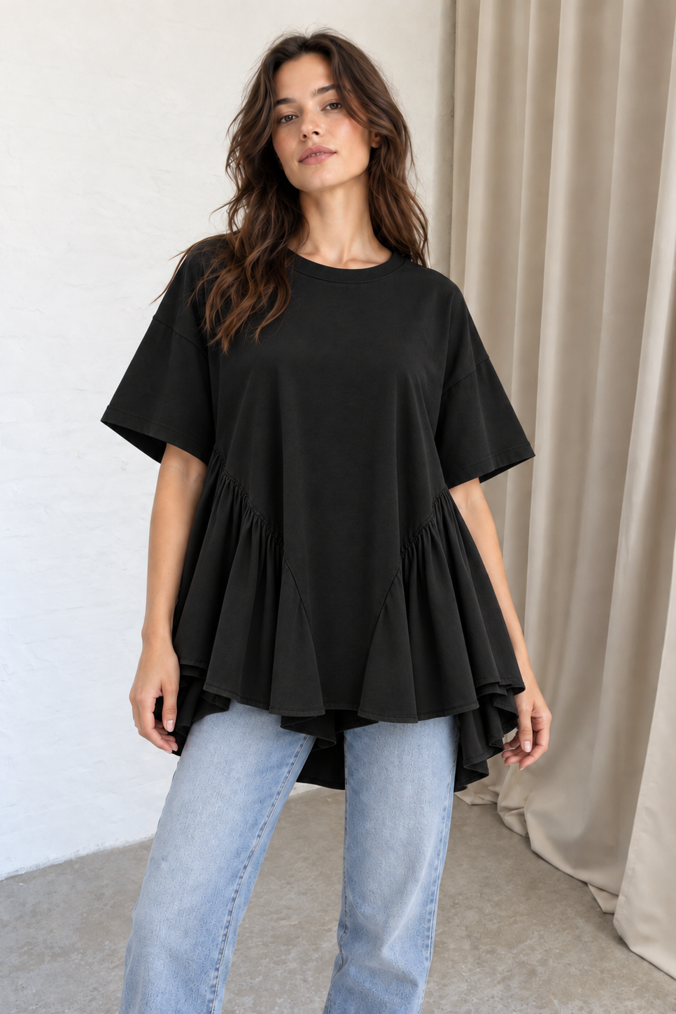Sort T-shirt fra Sassy Copenhagen giver den klassiske T-shirt et feminint og markant twist på mørkhåret kvinde