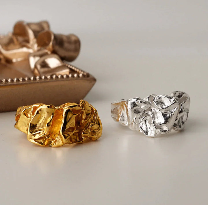 Andcopenhagen Arlinda ring i 18 karat guldbelagt og sølv 925, vist side om side på lys baggrund.