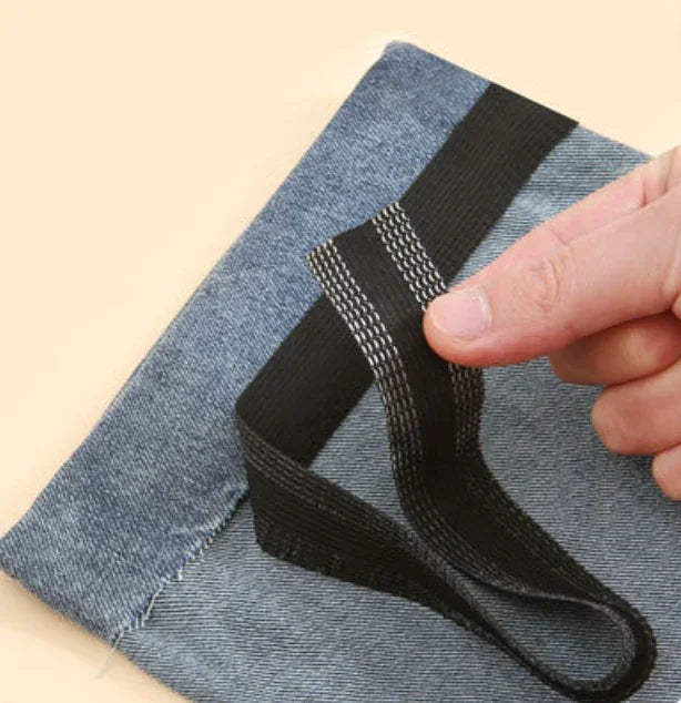 Sort 2m oplægningsbånd fra Andcopenhagen Basics vises på denimstof, klar til brug.