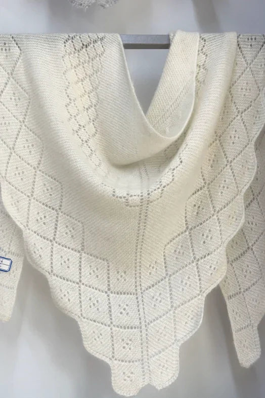 Hvidt trekantet cashmeretørklæde med hulmønster, udstillet på bøjle. 100% cashmere.