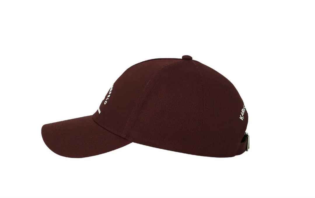 Kasket i burgundy med hvid tekst "KARL LAGERFELD PARIS 21 RUE ST-GUILLAUME" og justerbar strop.