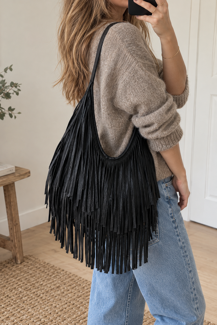 Megan er en smart og trendy skuldertaske med et cool, vintage-inspireret udtryk på kvinde med lækker strik og jeans