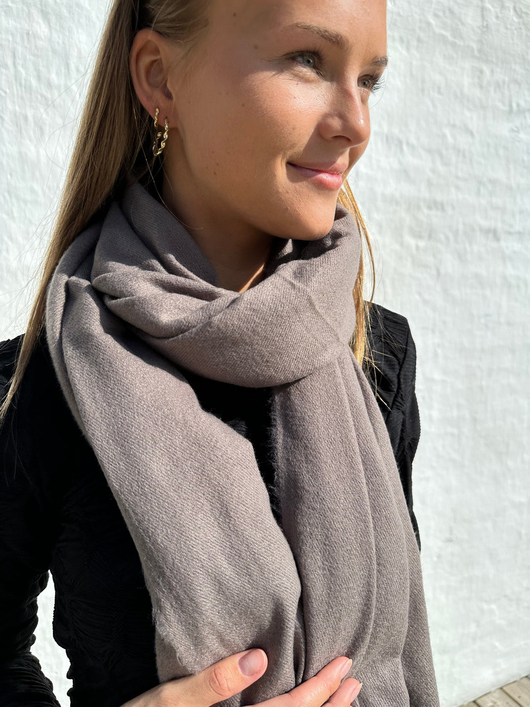 Kvinde med mørk kaffe cashmere tørklæde om halsen, ser blødt og varmt ud.