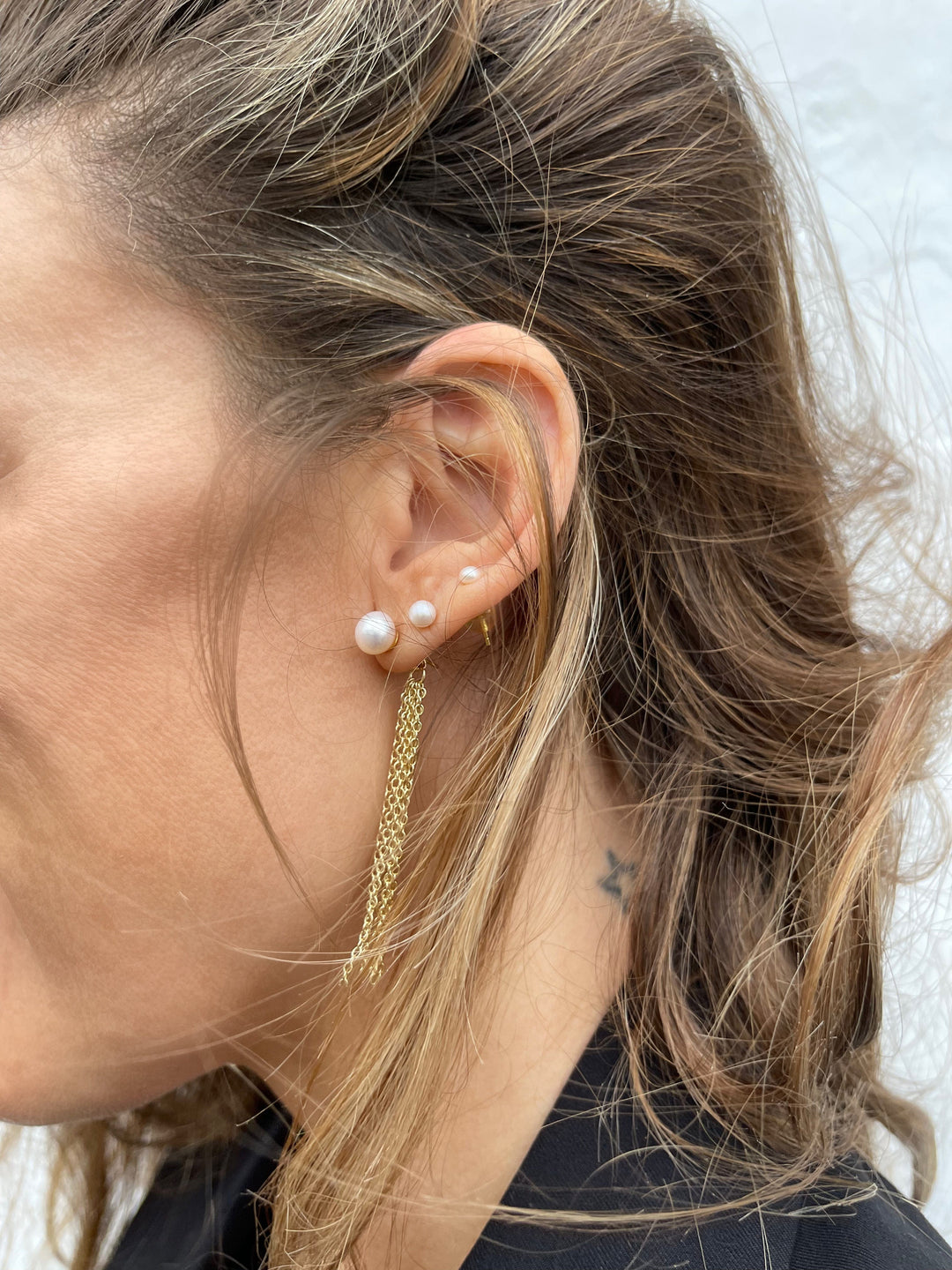 Ørering med kæde og perler i øret på kvinde med langt hår, 18 karat guldbelagt messing.