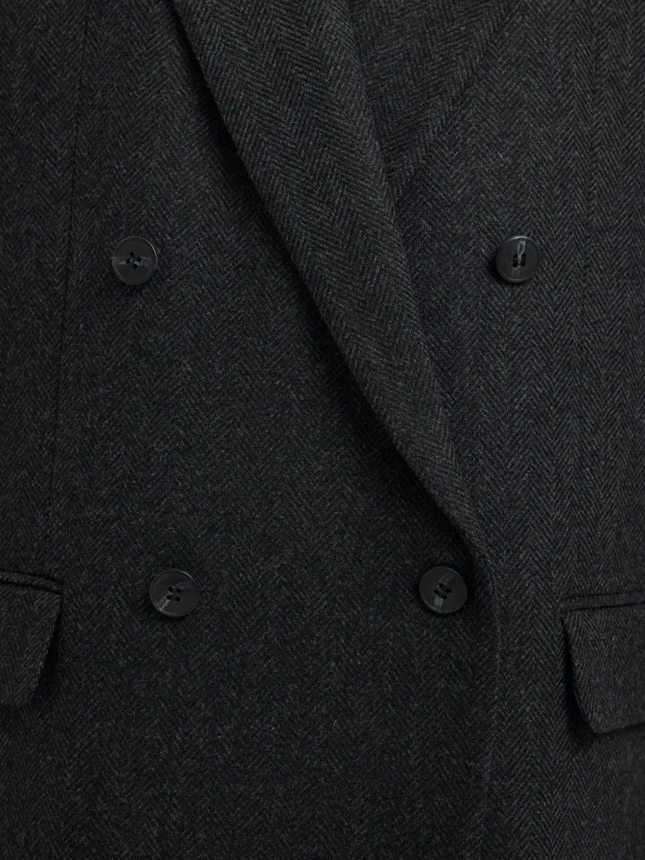 Sort uldblazer med dobbeltknappet design, to lommer foran og subtilt mønster i stoffet.