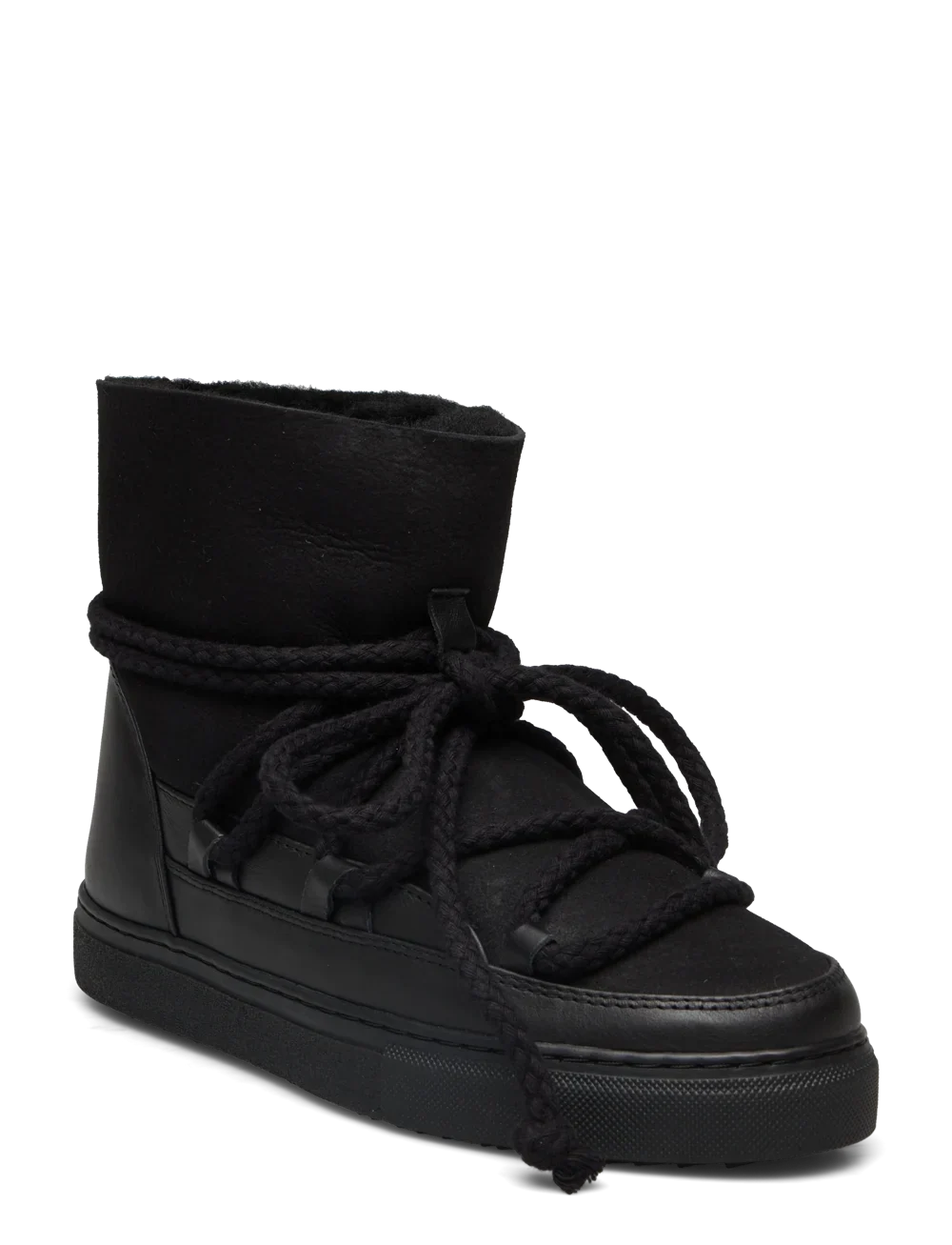 Sort vinterstøvle med højt skaft, tykke snørebånd og flad, mønstret sål. Mærke "INUIKII" synligt.