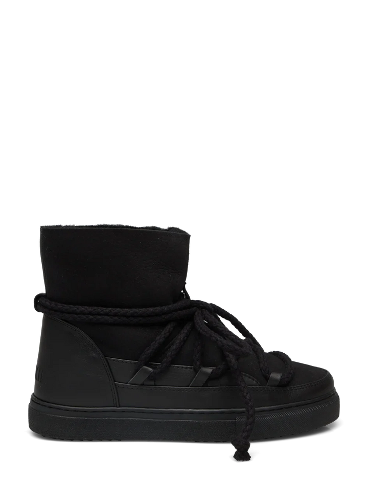 Sort vinterstøvle med højt skaft, tykke snørebånd viklet rundt, flad mønstret sål.