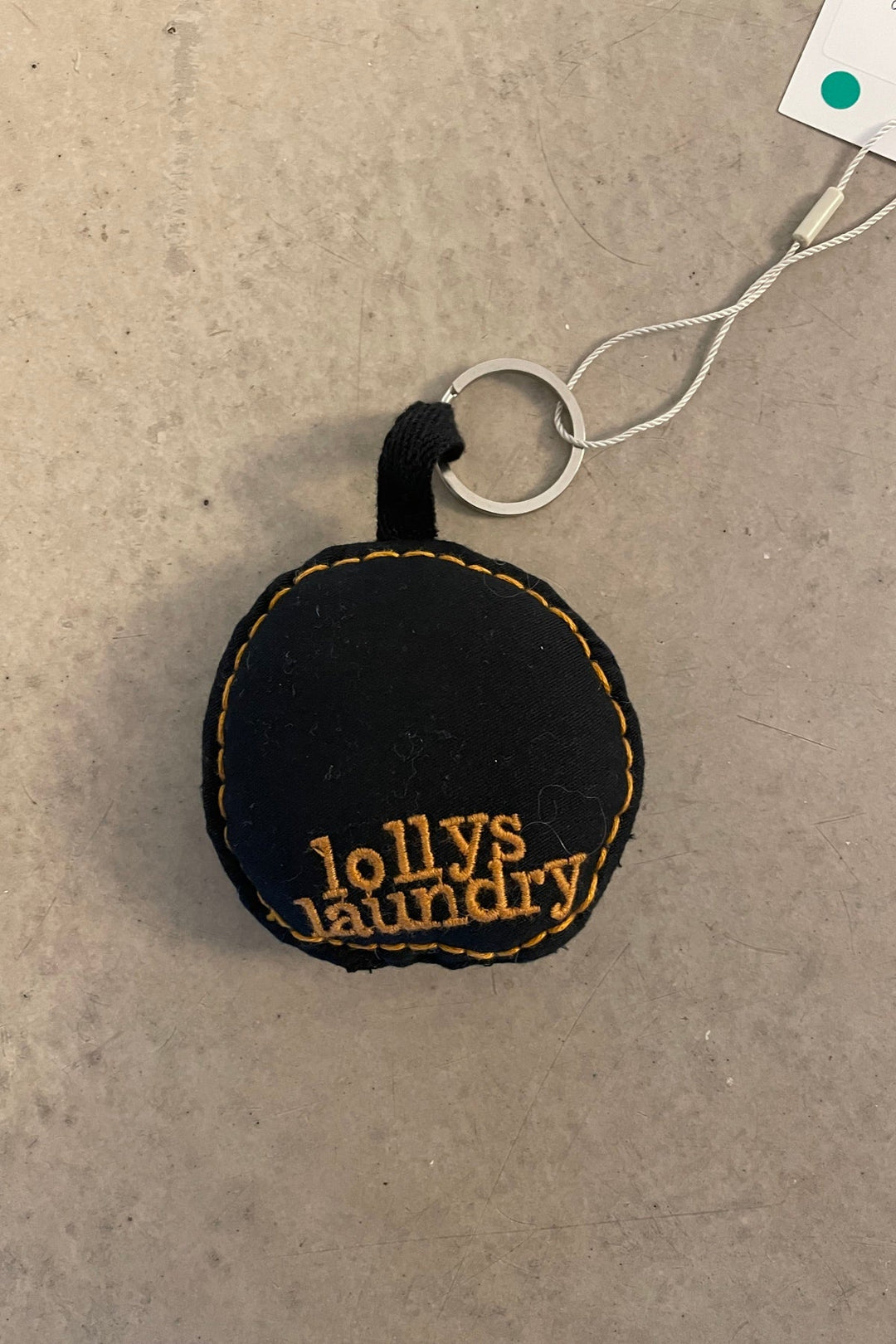 Lollys Laundry ButterflyLL Keychain in black cotton with embroidered logo, shown flat on a neutral background.