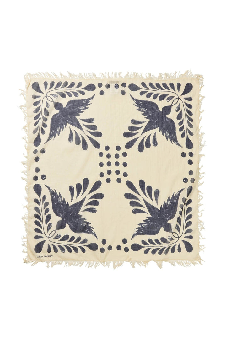 Lollys Laundry NoorLL Scarf in dark blue with a bird and leaf pattern, made of 100% cotton, shown flat with fringed edges.