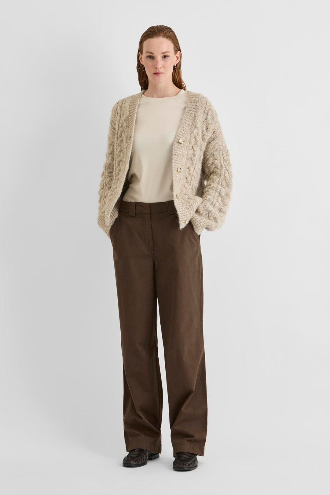Vila ROUFIONA HW W/F F/L TROUSER in dark brown cotton, wide-leg fit, worn by a model with a beige sweater and cardigan.