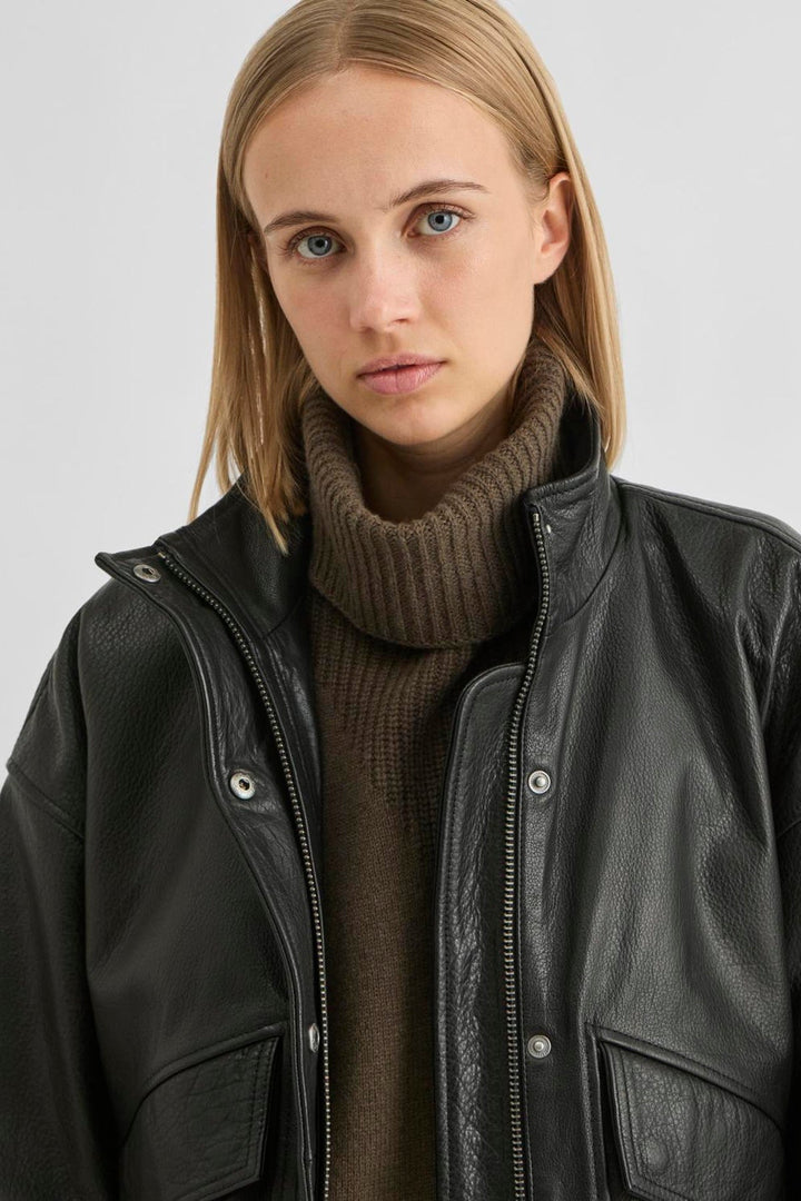 Vila ROUSIMONE oversized leather jacket in meteorite black, shown worn by a model, featuring a biker collar and long sleeves.