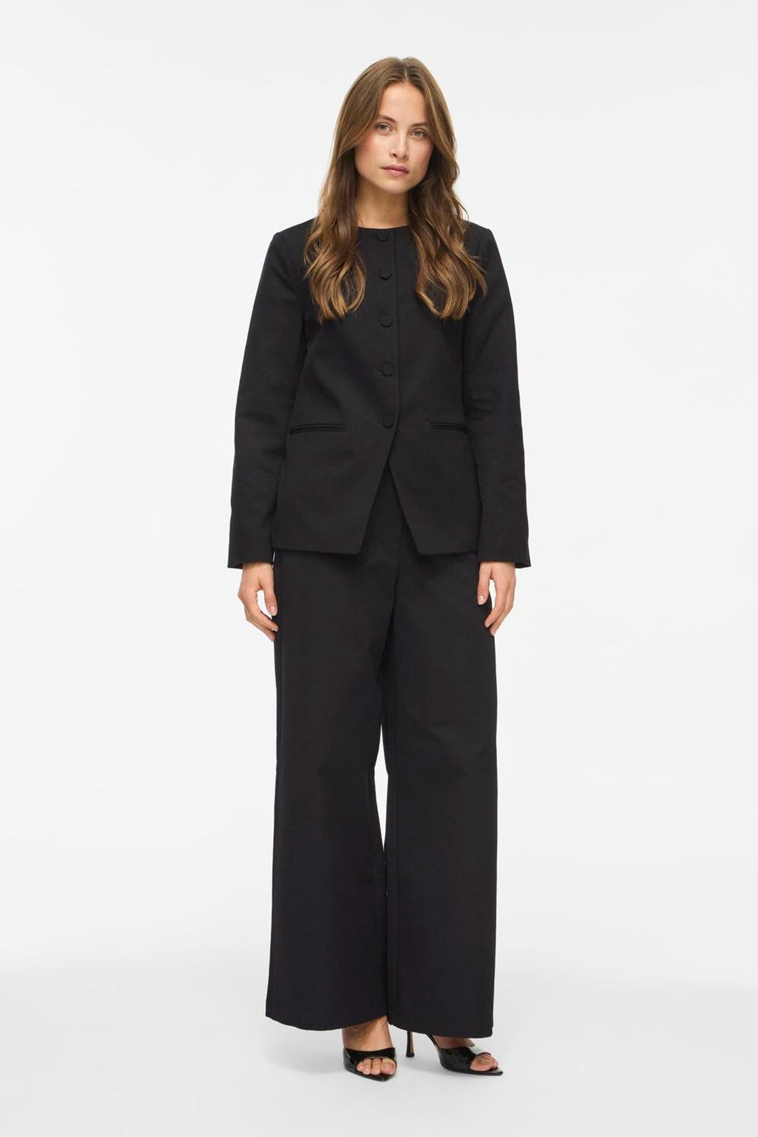 Vila Vichiona long sleeve black blazer made of 100% polyester, featuring a round neckline and button closure, worn by a model
