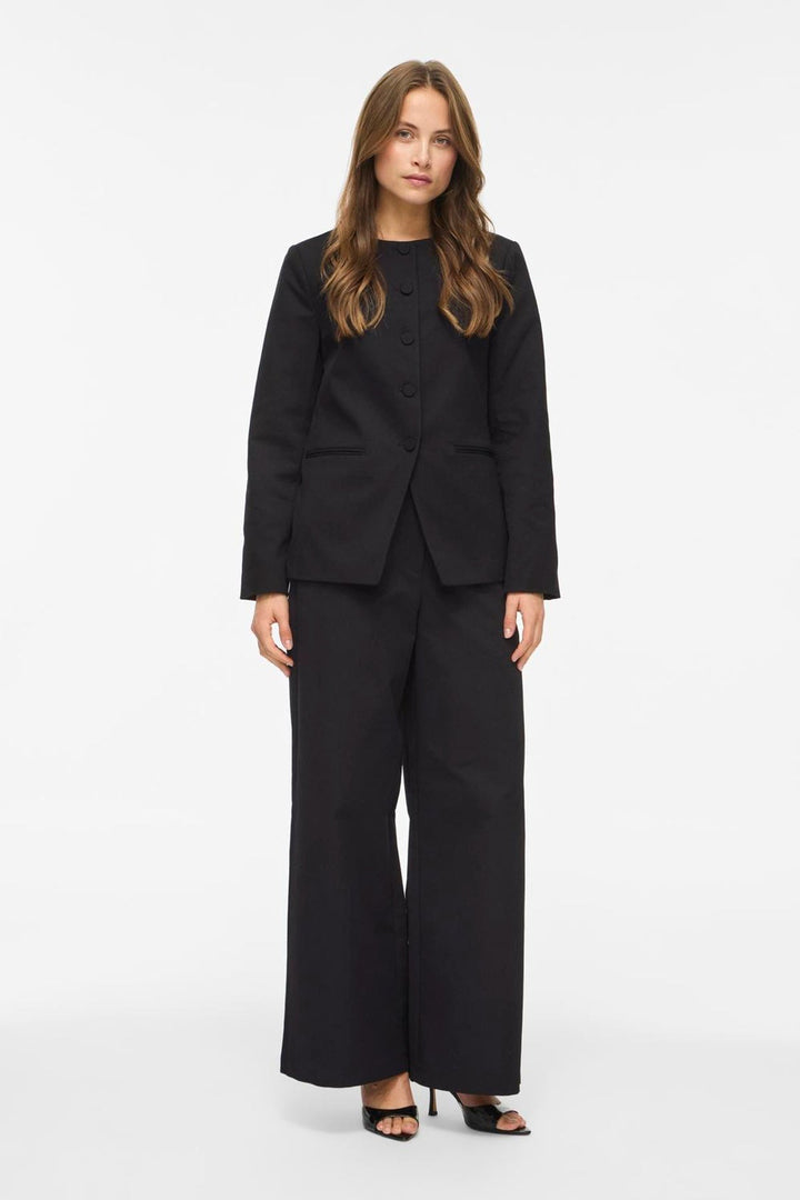 Vila Vichiona long sleeve black blazer made of 100% polyester, featuring a round neckline and button closure, worn by a model